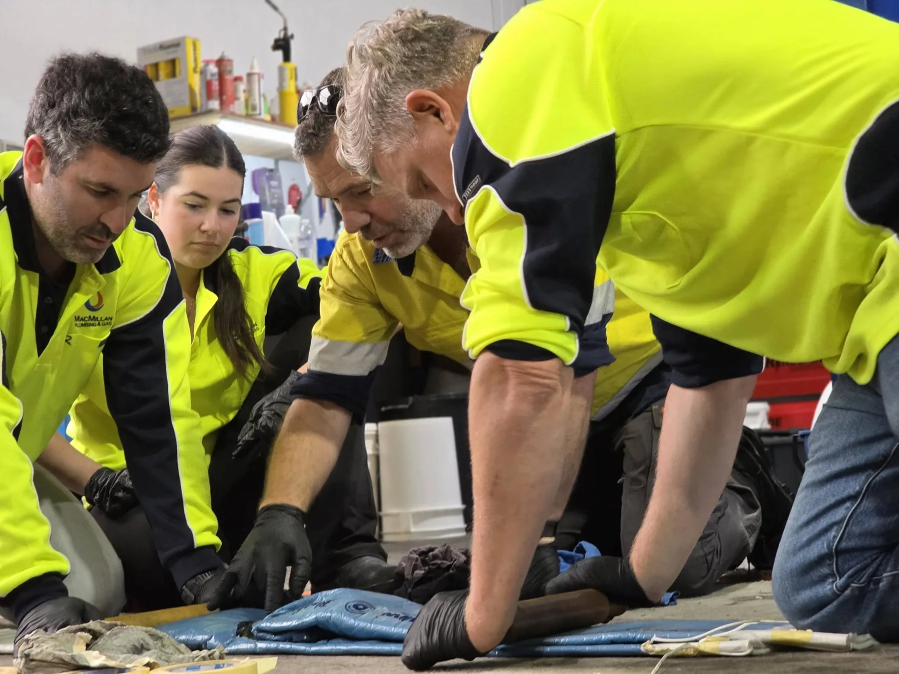 Technicians preparing pipe lining materials during a practical training session